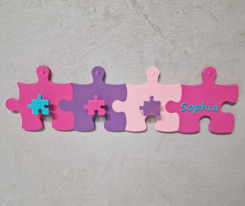 Kinderzimmer Garderoben-Erweiterung mit bunten Puzzlestücken und Namensschild für individuelles Design