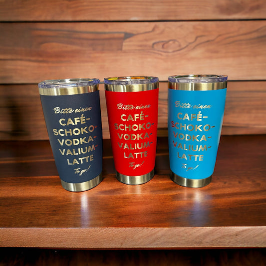 Personalisierter Thermobecher 590ml in drei Farben mit lustigen Sprüchen auf dem Tisch