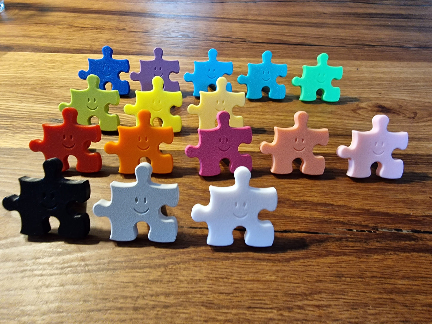Kindergarderobe Puzzle – Bunte, personalisierbare Puzzle-Haken für Kinderzimmer, mit lächelnden Gesichtern.