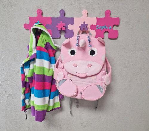 Kinderzimmer Garderoben-Erweiterung mit personalisiertem Namensschild und kindgerechten Haken für Jacken und Rucksäcke.