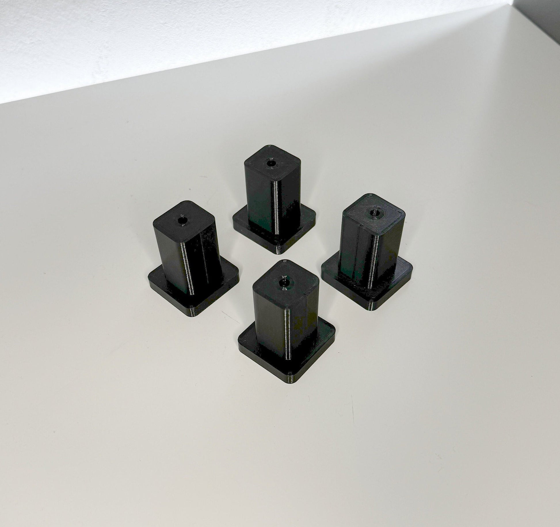 Xtool F1 Riser XL – vier schwarze Erhöhungen für die Lasergravur von Objekten.