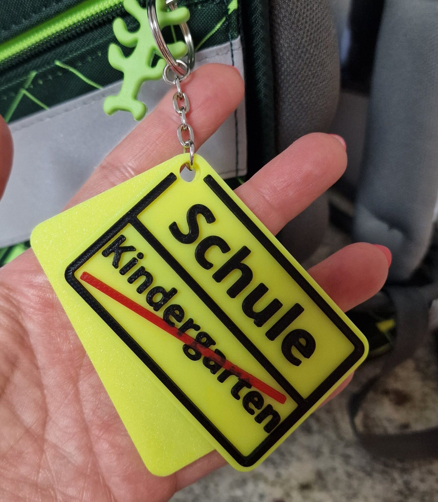Personalisierter Anhänger mit Namen in gelb und schwarz, ideal für Schulranzen oder Taschen.