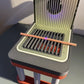 xTool F1 Jigs Set image featuring a laser engraver with a wooden stick on the grill surface.