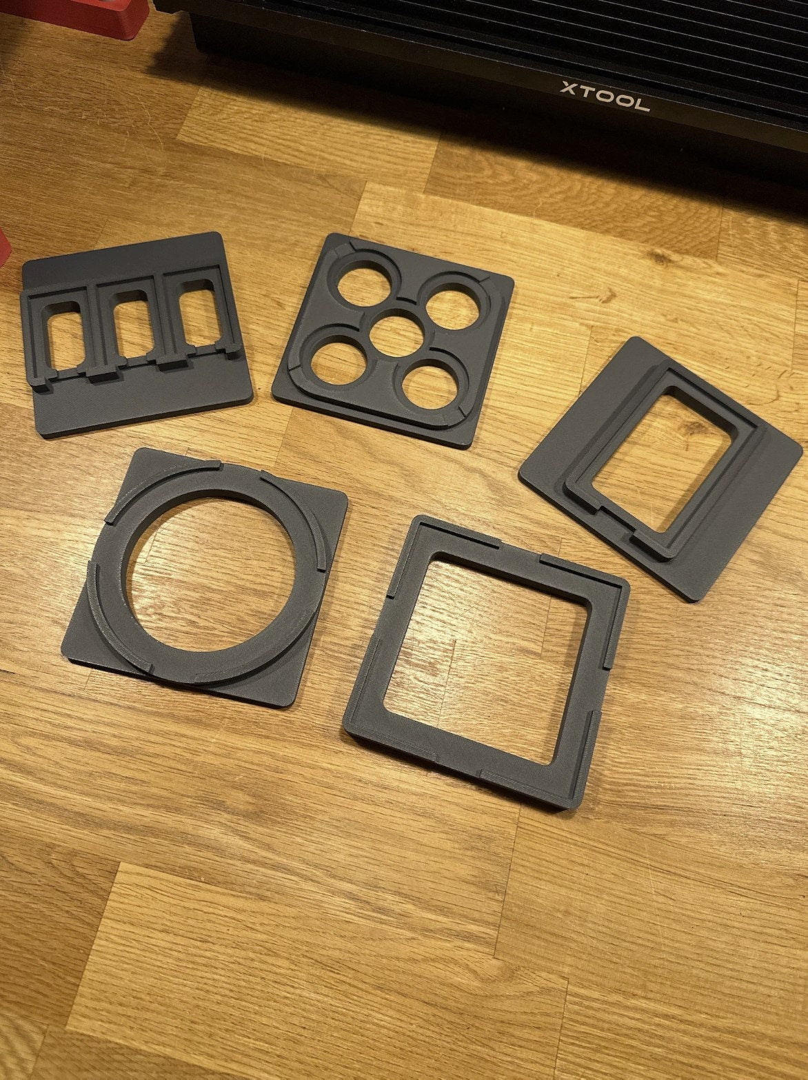 xTool F1 Jigs Set displaying 6 gray base plates for laser engraving projects on a wooden surface.