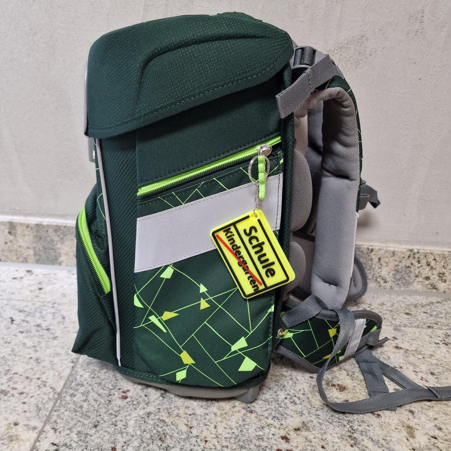 Personalisierter Anhänger mit Namen an einem grünen Schulranzen, ideal für individuelle Geschenke.