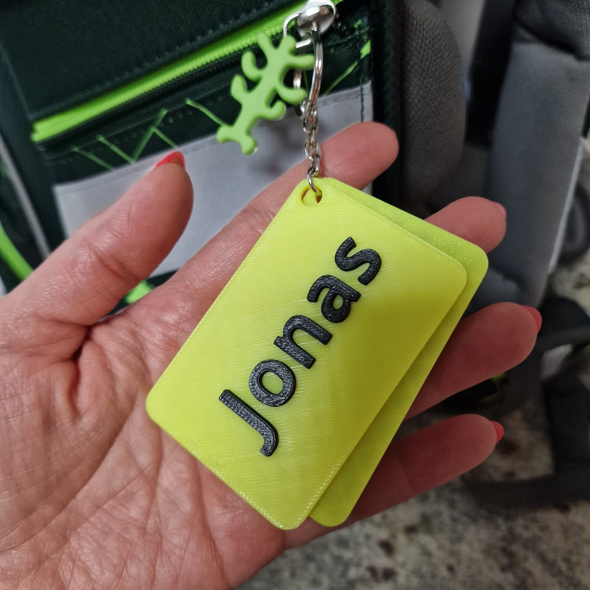 Personalisierter Anhänger mit Namen in leuchtendem Gelb mit der Gravur "Jonas".